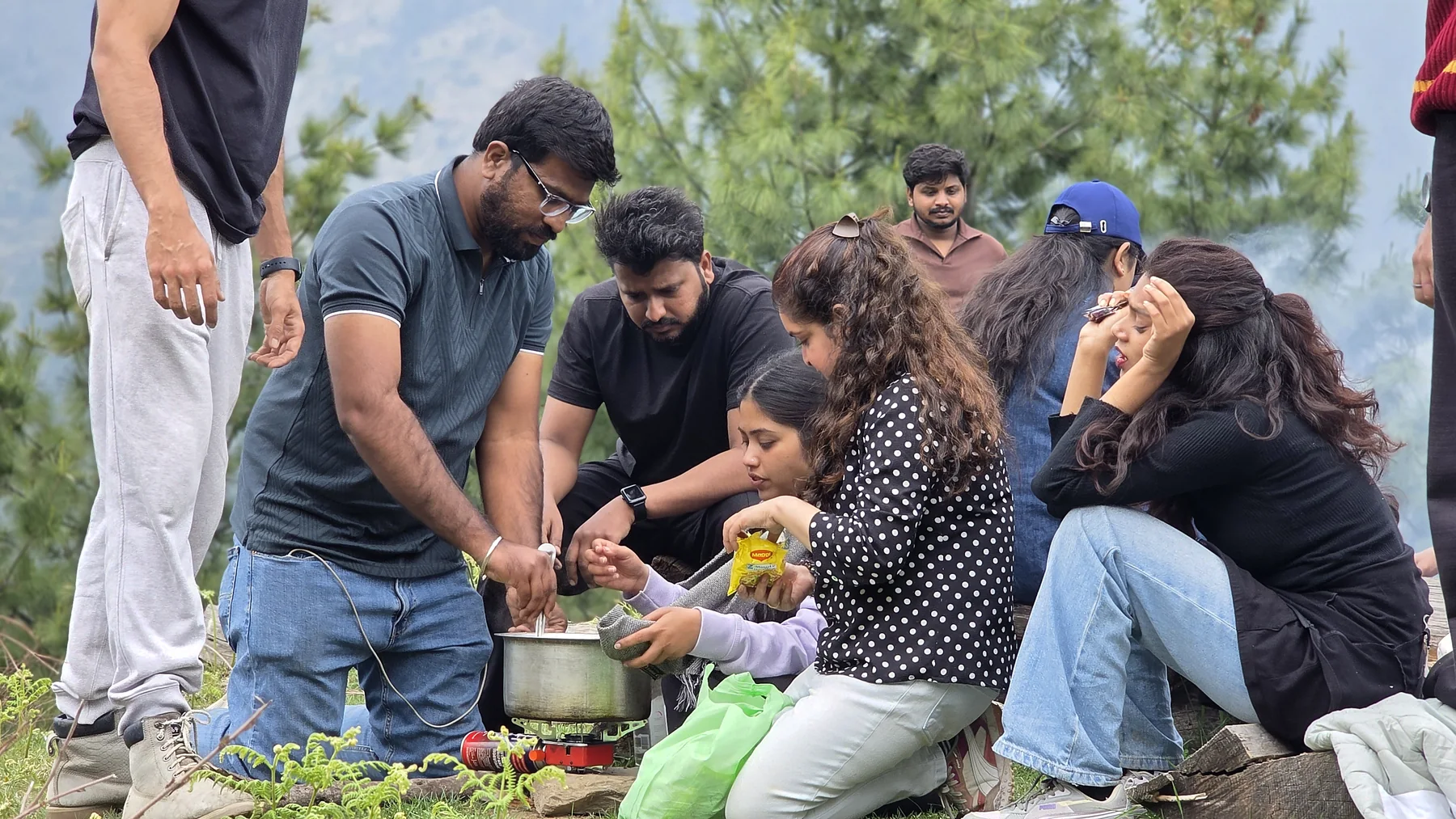 Safar travellers preparing ingredients beside an outdoor cooking pot