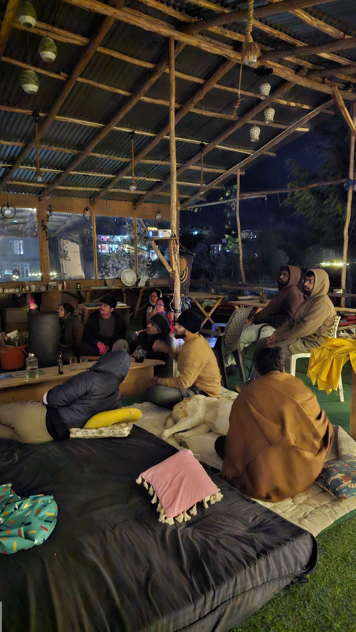 Safar travellers gathered around tables during a movie night